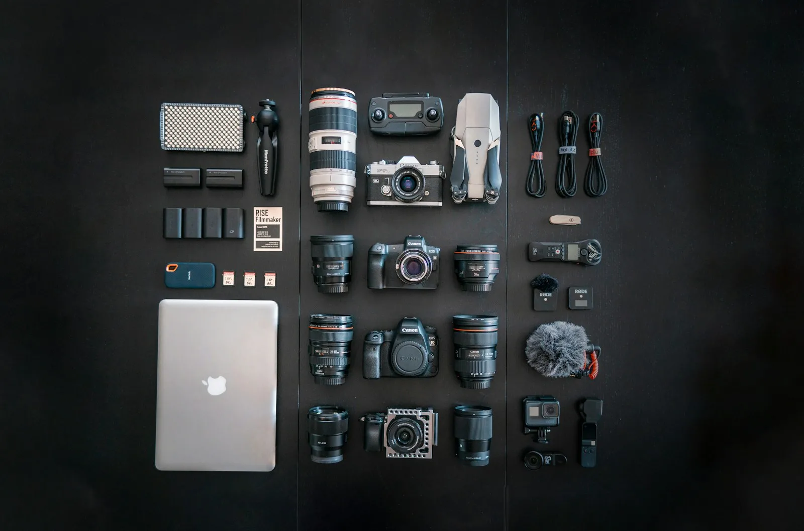 silver macbook black dslr camera and black dslr camera