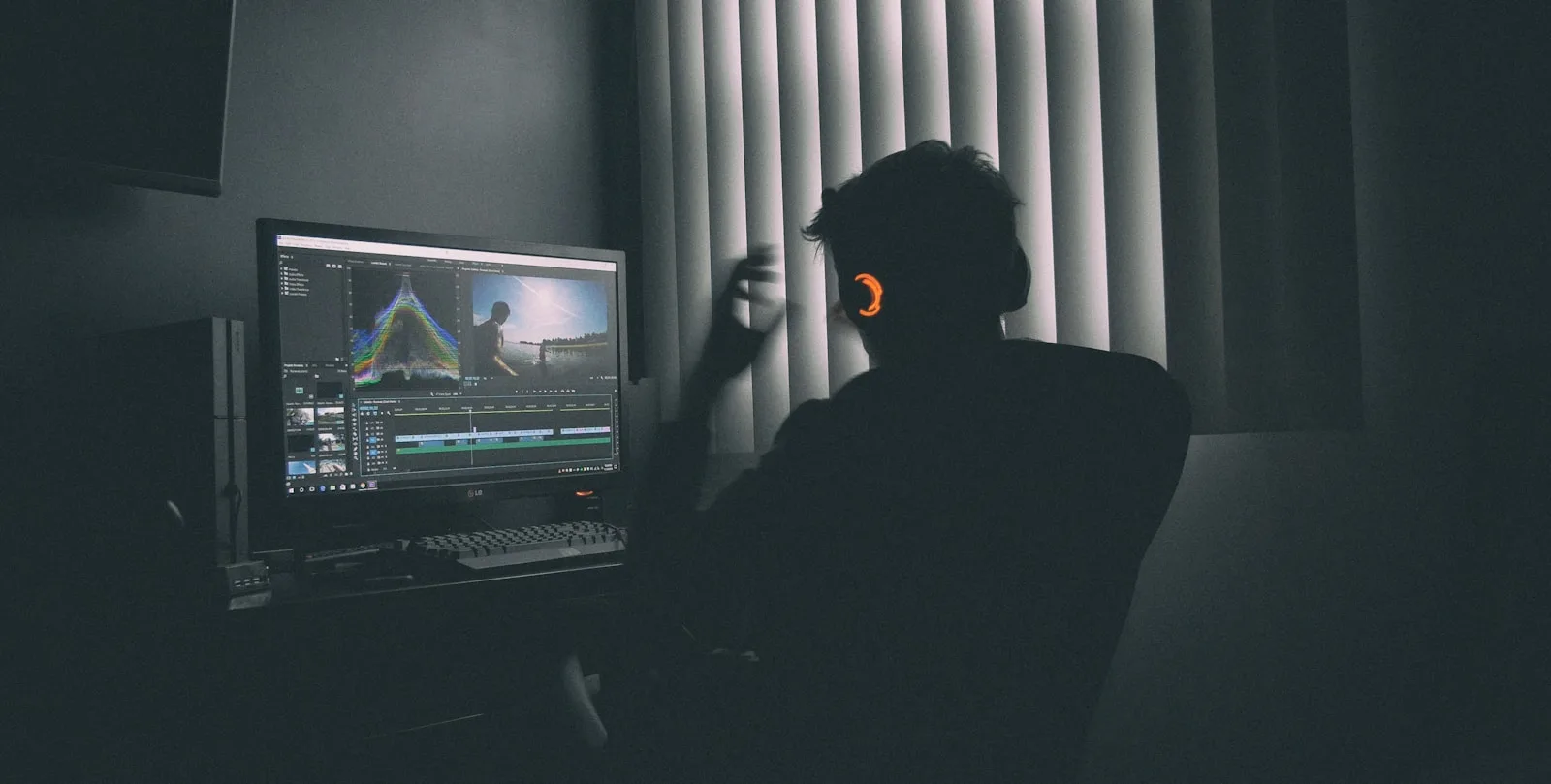 shallow focus photography of man listing to music in front of the computer